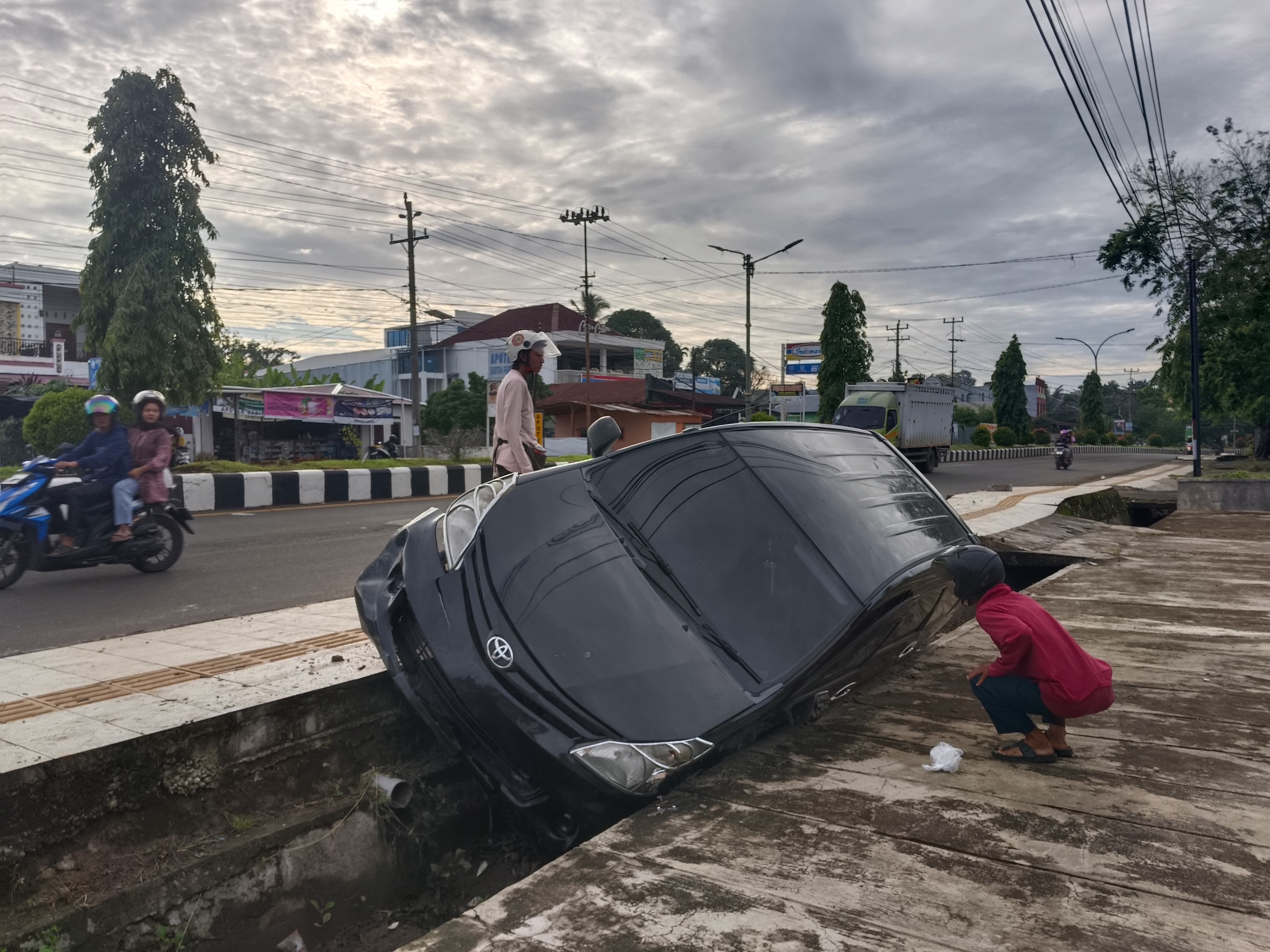 Sopir Hilang Kendali, Mobil Avanza Melompati Trotoar lalu Masuk Siring